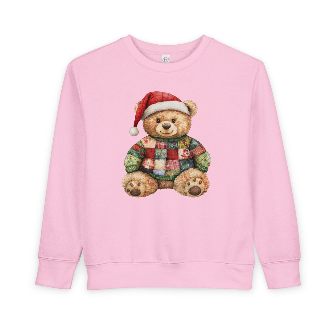 Light-pink toddler sweatshirt with teddy bear in Santa hat and patchwork sweater, emphasizing warmth and comfort.