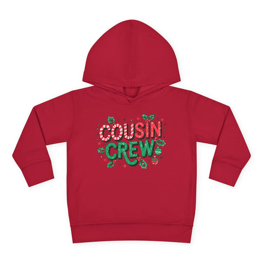 Cousin Crew Christmas Toddler Hoodie with candy-cane style COUSIN and green CREW, adorned with festive holly, snowflakes, and ornaments, featuring durable, cozy design.