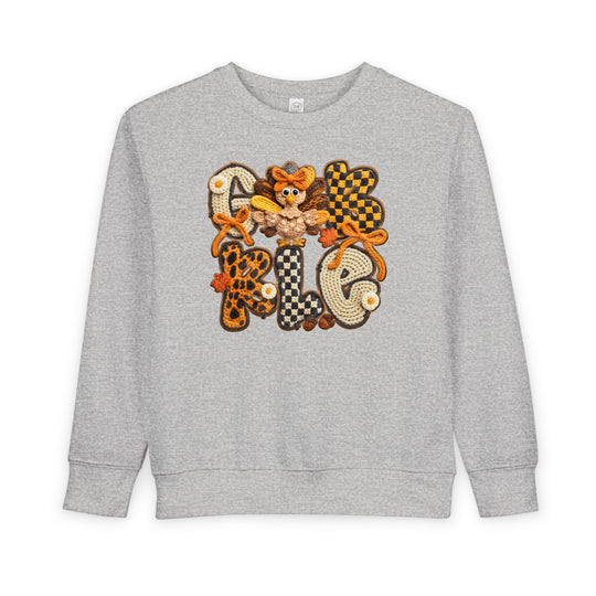 Gobble Toddler Crew: Light-gray sweatshirt with GOBBLE appliqué in plaid and leopard patterns, featuring a cartoon turkey and fall leaves, perfect for cozy autumn wear.