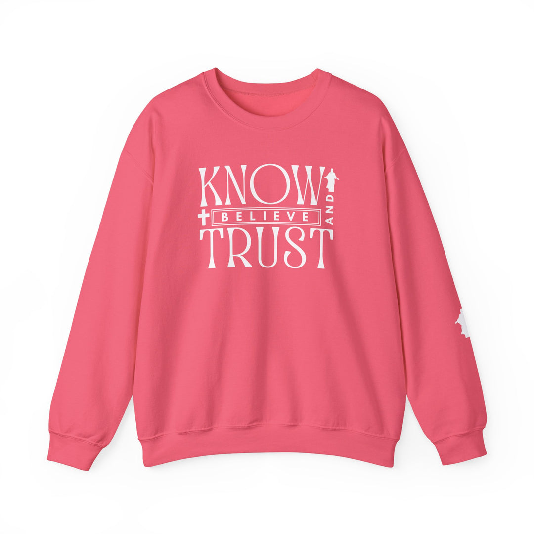 Trust, Know, Believe Crew sweatshirt features bold white text on a pink background, showcasing its cozy, durable design with ribbed collar and no side seams.
