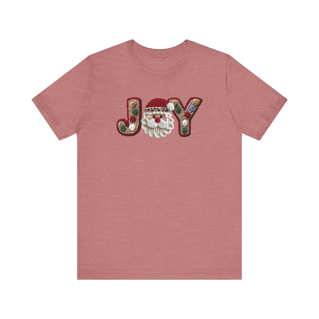 Heathered red-pink Joy Tee with Santa face replacing O, and textured J and Y featuring holly berries. Cozy, unisex fit from Faith Family Designs.