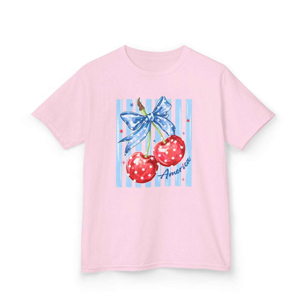 American Cherry Kids Tee featuring red cherries with stars and a blue ribbon on light pink. Durable, soft cotton, perfect for everyday wear.