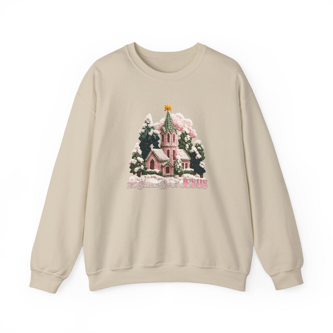 Light-beige crewneck sweatshirt with a Christmas graphic, featuring a snow-covered church, fir trees, and The Greatest Gift is JESUS slogan.