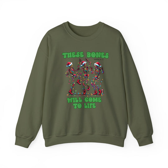 Olive-green sweatshirt with dancing skeletons adorned in Christmas lights and Santa hats, featuring THESE BONES WILL COME TO LIFE and Ezekiel reference. Cozy, durable fabric blend.