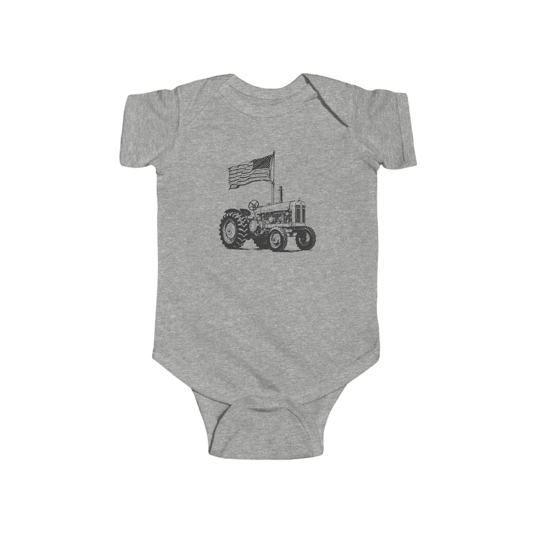 American Boy Onesie: Heather-gray baby bodysuit featuring a tractor with a waving American flag, crafted for durability and softness with ribbed knitting and easy-change snaps.