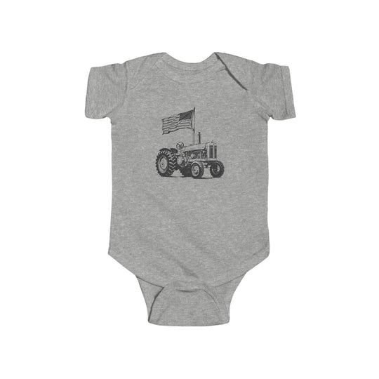 American Boy Onesie: Heather-gray baby bodysuit featuring a tractor with a waving American flag, crafted for durability and softness with ribbed knitting and easy-change snaps.