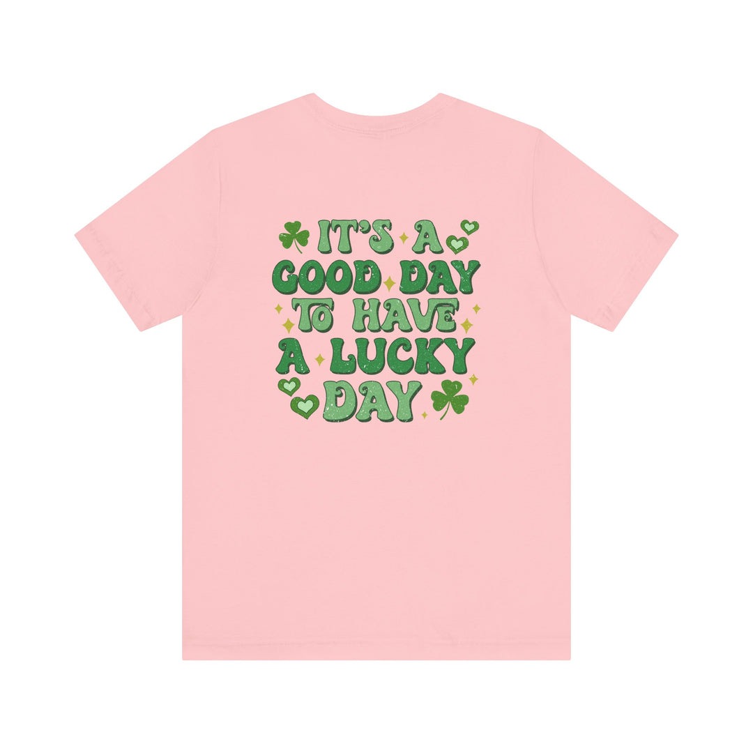 Good Day Lucky Day Tee, a pink jersey t-shirt with green text, featuring a soft cotton blend and ribbed knit collar for comfort and durability.