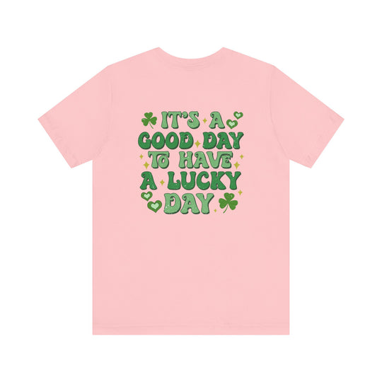 Good Day Lucky Day Tee, a pink jersey t-shirt with green text, featuring a soft cotton blend and ribbed knit collar for comfort and durability.