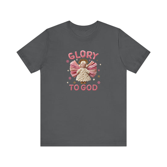 Glory to God Tee: Dark-gray T-shirt with knitted-style angel design, pink wings, cream body, stars, and 'GLORY TO GOD' text, in soft, durable cotton.