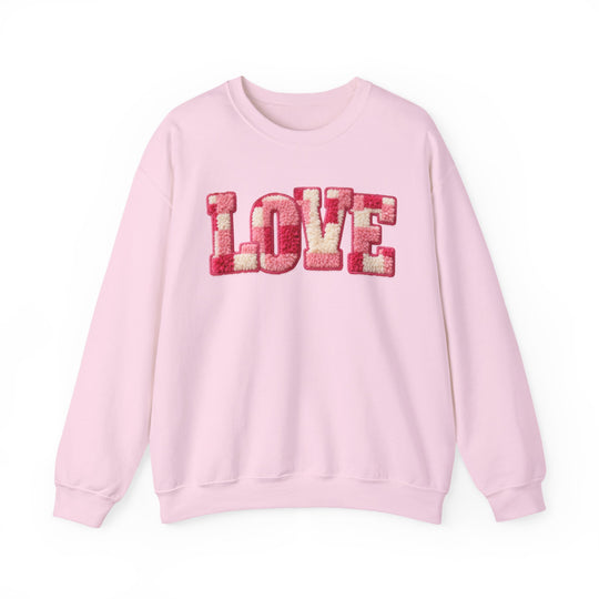 Light-pink Love Crew sweatshirt with chenille-style letters, showcasing a comfortable, unisex fit and ribbed knit collar for durability.