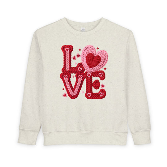 Love Heart Toddler Crew: Off-white sweatshirt with LOVE in red and pink, featuring knitted heart accents. Made from cozy cotton-polyester blend, perfect for toddlers.