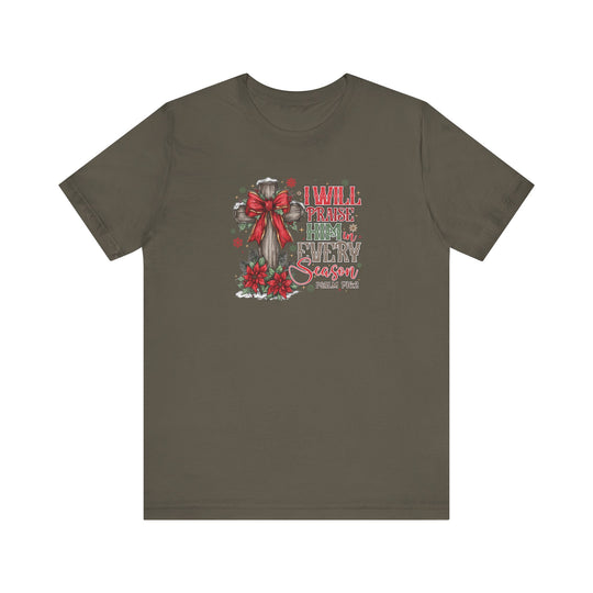 Praise Him in Every Season Tee features a wooden cross with a red bow, poinsettias, pine, snowflakes, and Psalm 145:2 in festive lettering.