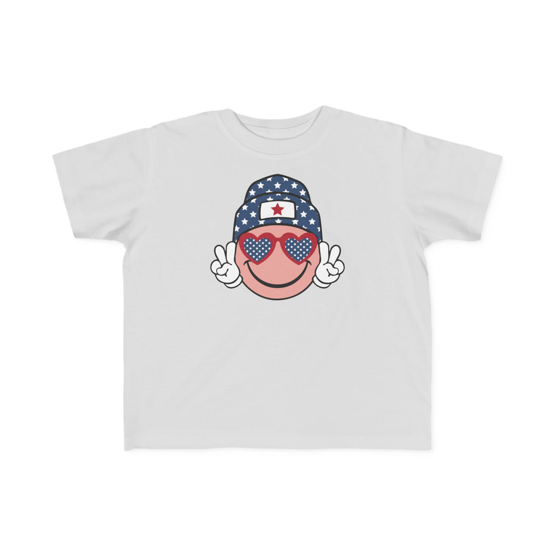 American Girl Toddler Tee: White shirt with cartoon face, sunglasses, and hat. Soft 100% cotton, light fabric, tear-away label. Sizes: 2T, 3T, 4T, 5-6T. Perfect for sensitive skin.