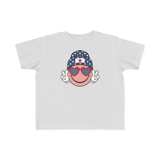 American Girl Toddler Tee: White shirt with cartoon face, sunglasses, and hat. Soft 100% cotton, light fabric, tear-away label. Sizes: 2T, 3T, 4T, 5-6T. Perfect for sensitive skin.