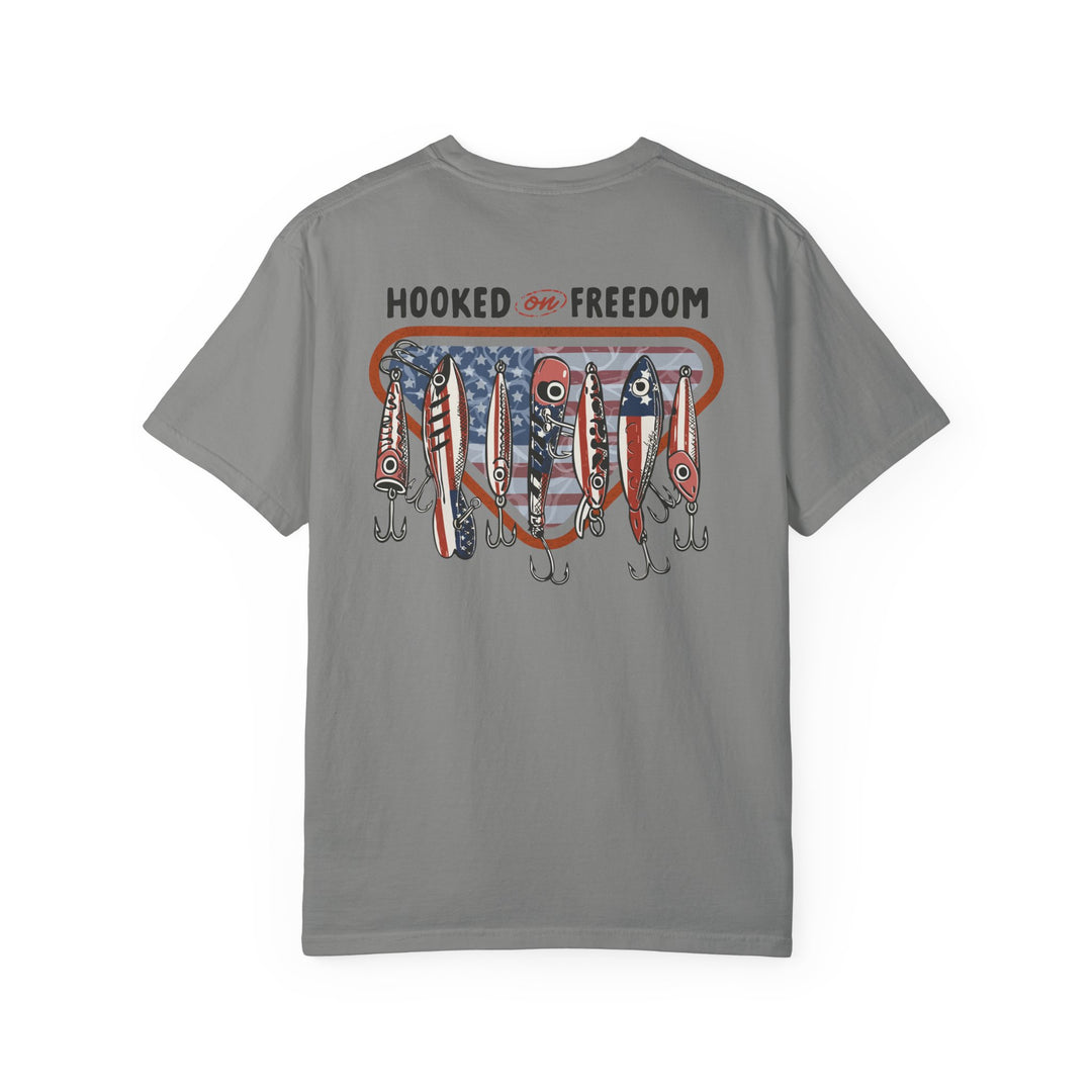 Hooked on Freedom Tee: Gray shirt featuring 'HOOKED ON FREEDOM' text with heart-shaped stars-and-stripes and red, white, blue fishing lures, reflecting a patriotic fishing theme.