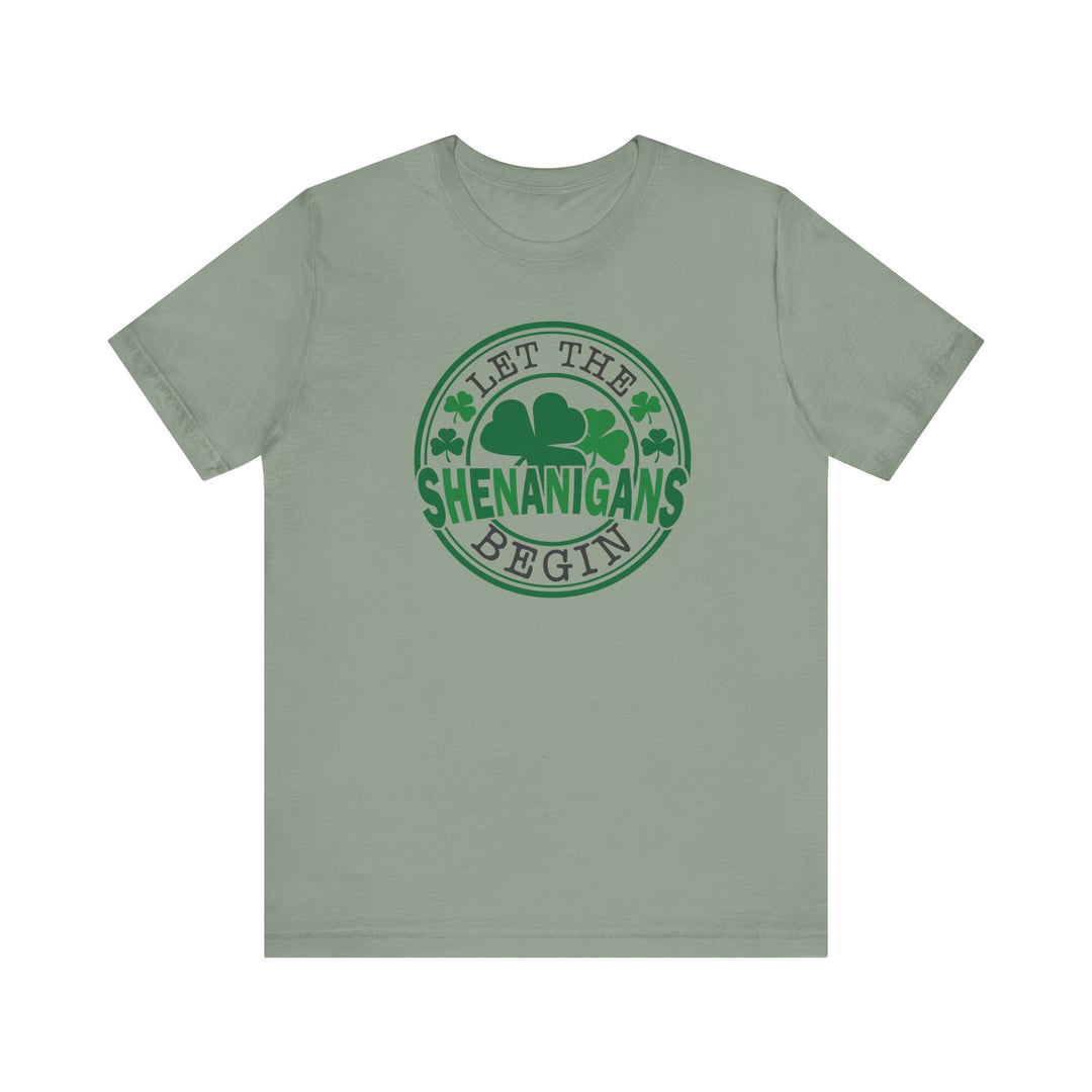 Let The Shenanigans Begin Tee featuring a green clover logo, classic fit with ribbed knit collars, made from soft Airlume combed cotton.