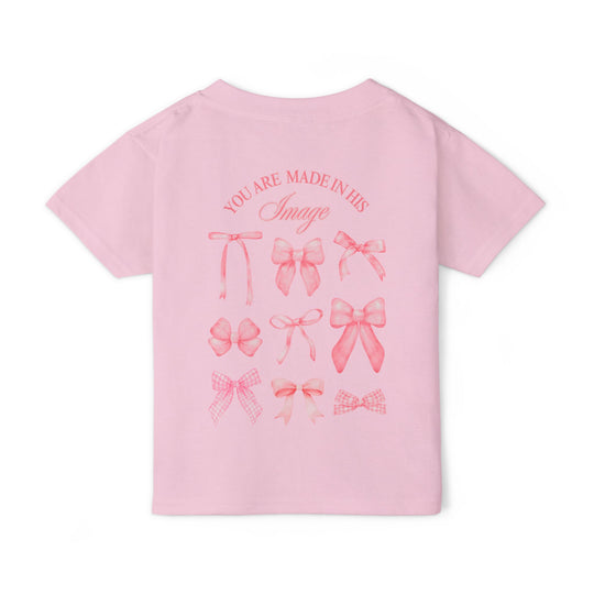 Heavy Cotton™ Toddler T-shirt in light pink with short sleeves, featuring nine pink bows and faith-inspired text on the back, offering comfort and style.