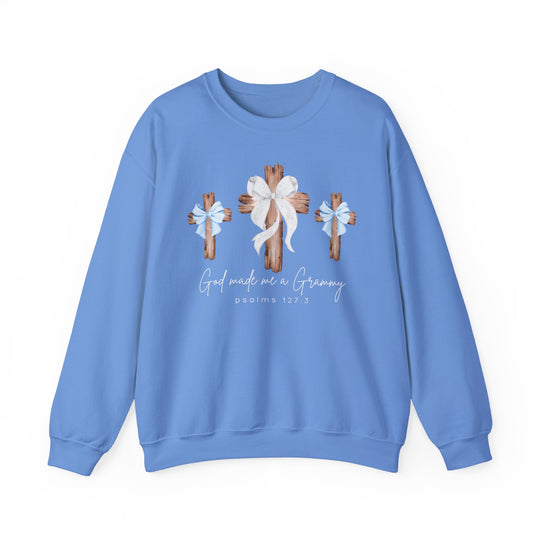 Light-blue crewneck sweatshirt featuring God Made Me Boy Grammy design with three wooden crosses, bows, and psalms 127:3 script, emphasizing comfort and style.