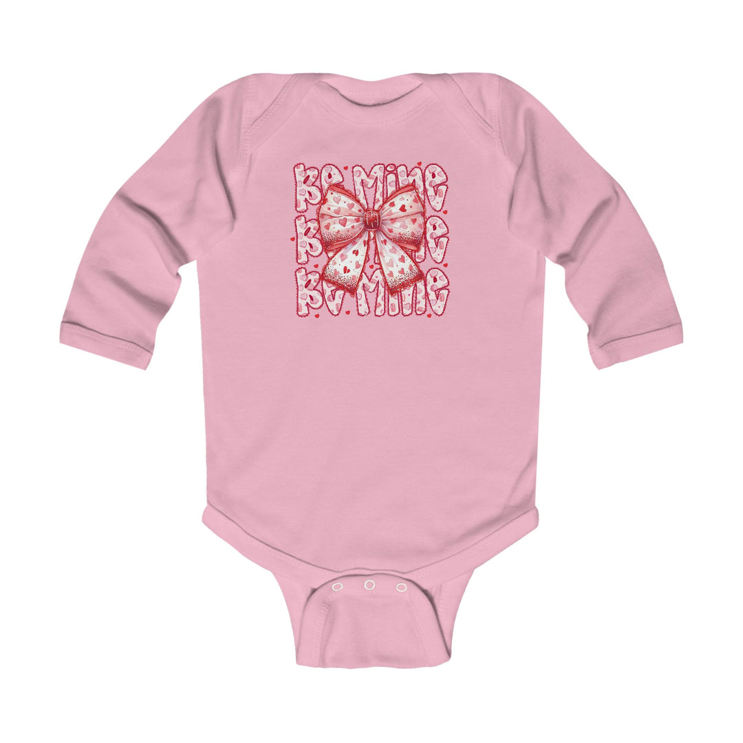 Be Mine Onesie: Pink long-sleeve baby bodysuit with heart-spotted bow and Be Mine print, featuring durable ribbed bindings and easy-change snaps.