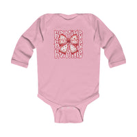 Be Mine Onesie: Pink long-sleeve baby bodysuit with heart-spotted bow and Be Mine print, featuring durable ribbed bindings and easy-change snaps.
