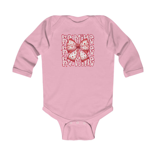 Be Mine Onesie: Pink long-sleeve baby bodysuit with heart-spotted bow and Be Mine print, featuring durable ribbed bindings and easy-change snaps.