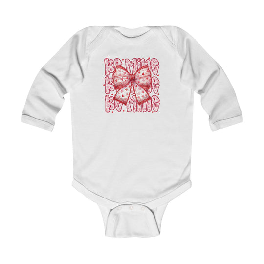 Be Mine Onesie: White infant bodysuit featuring a pink bow with heart patterns and Be Mine text, designed for comfort with 100% cotton and easy-change snaps.