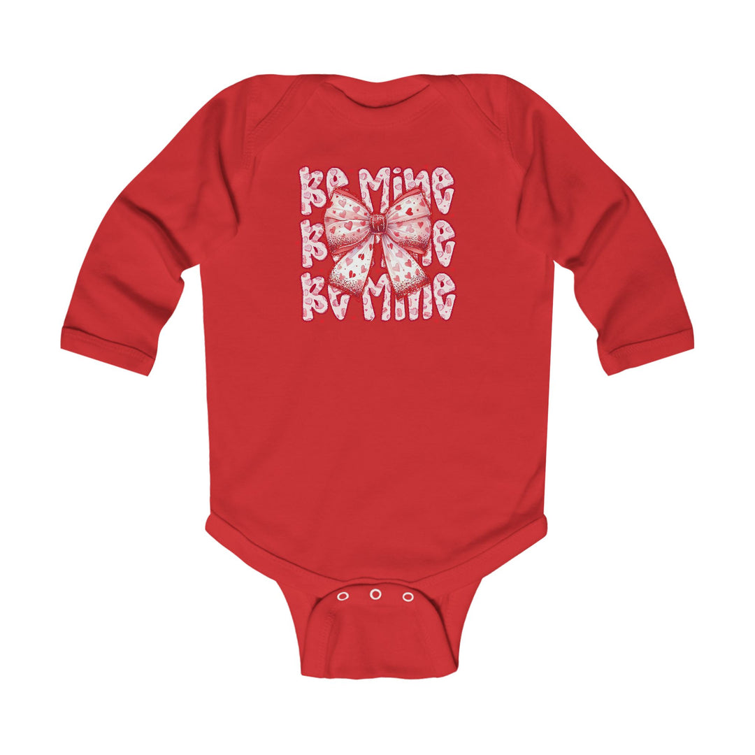 Be Mine Onesie: Red long-sleeved baby bodysuit featuring a pink heart-patterned bow and BE MINE text, with durable snap closures for easy changing.