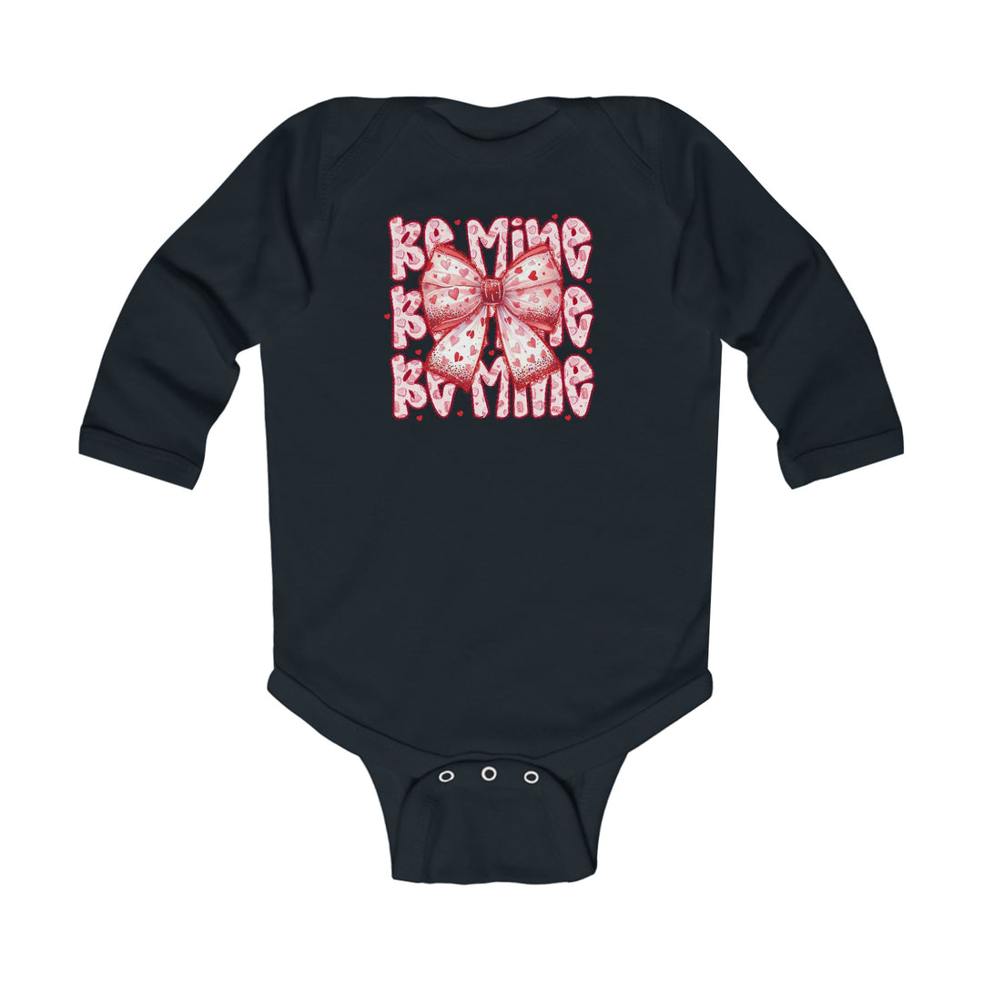 Be Mine Onesie: Navy long-sleeved infant bodysuit featuring a pink heart-patterned bow and Be Mine text, with snap closures for easy changing.