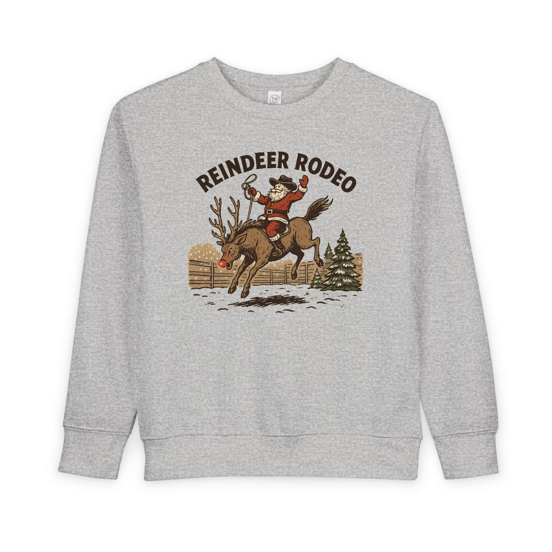 Light-gray Reindeer Toddler Crew sweatshirt with cowboy Santa on a bucking reindeer, blending holiday charm with a western rodeo theme. Perfect for cozy, festive wear.
