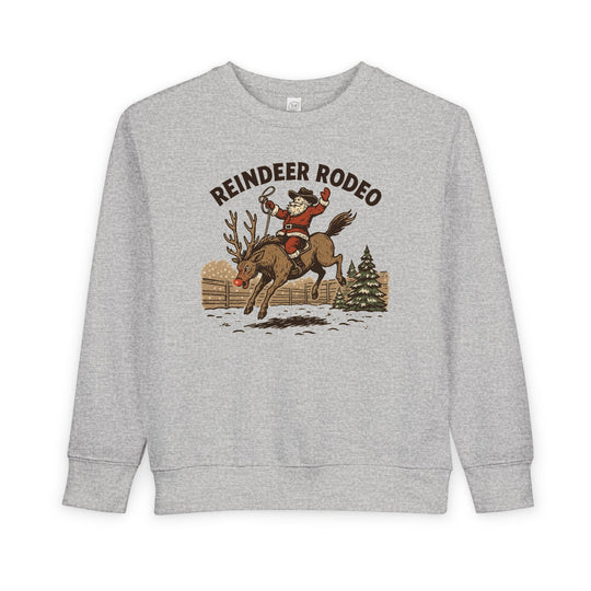 Light-gray Reindeer Toddler Crew sweatshirt with cowboy Santa on a bucking reindeer, blending holiday charm with a western rodeo theme. Perfect for cozy, festive wear.