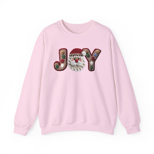 Light pink crewneck sweatshirt, JOY with Santa face motif and pom-pom accents, offers cozy comfort and durability, perfect for colder months.
