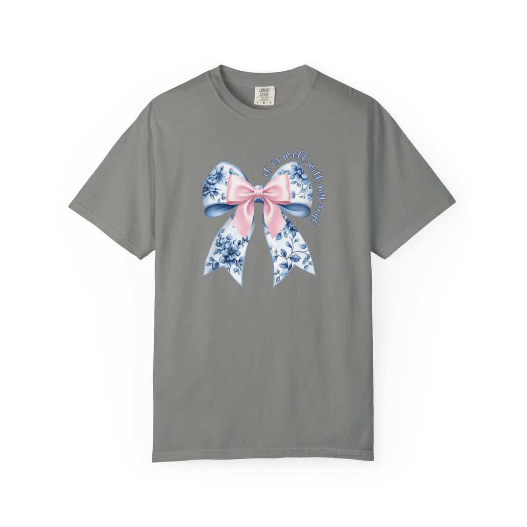 It is Well With My Soul Tee features a decorative bow with a floral pattern on a gray T-shirt, combining comfort and faith-inspired design.