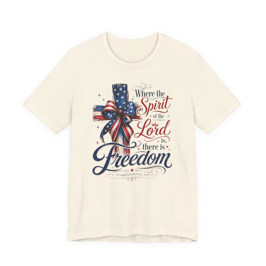 Spirit of the Lord Tee featuring a patriotic cross design with an American-flag bow and Bible verse, highlighting faith and freedom on a cream T-shirt.