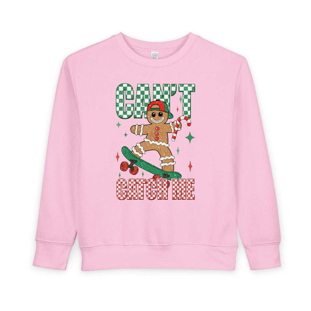 Can't Catch Me Toddler Crew features a playful gingerbread cookie graphic on a pink sweatshirt, perfect for keeping toddlers cozy and stylish during the holidays.