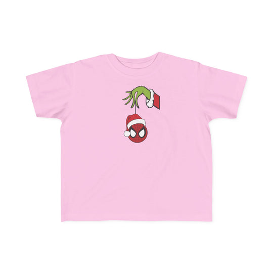 Spider Ball Christmas Toddler Tee features the Grinch's hand holding a Spider-Man ornament with a Santa hat, perfect for toddlers with soft, durable fabric.