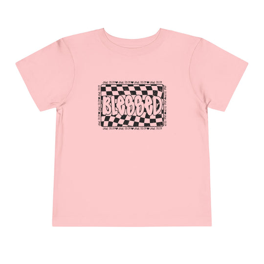 Blessed Toddler Tee, a pink short sleeve t-shirt with black and white checkered design, made from soft cotton for comfort. Ideal for adding style to toddlers' daily wear.