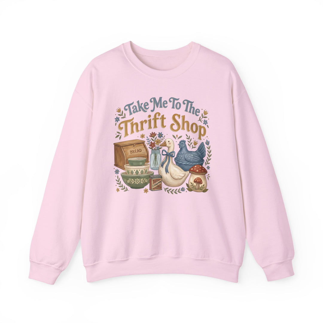Light-pink crewneck sweatshirt with “Take Me To The Thrift Shop” and vintage-style thrift items, including a wooden bread box and ceramic birds, in folk-art style.
