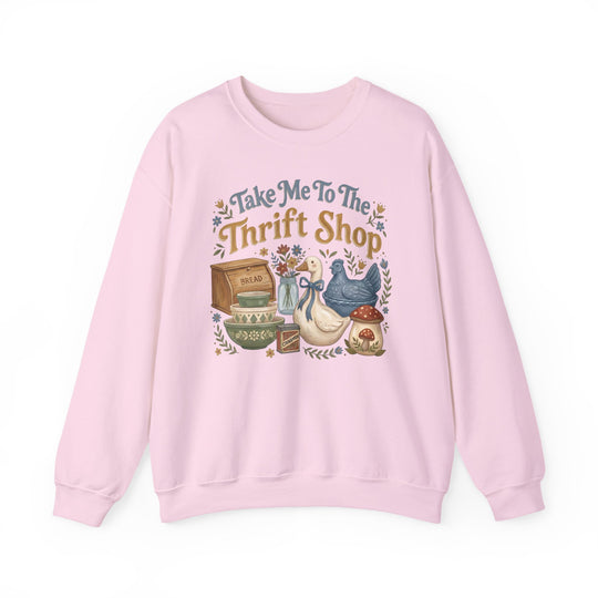 Light-pink crewneck sweatshirt with “Take Me To The Thrift Shop” and vintage-style thrift items, including a wooden bread box and ceramic birds, in folk-art style.