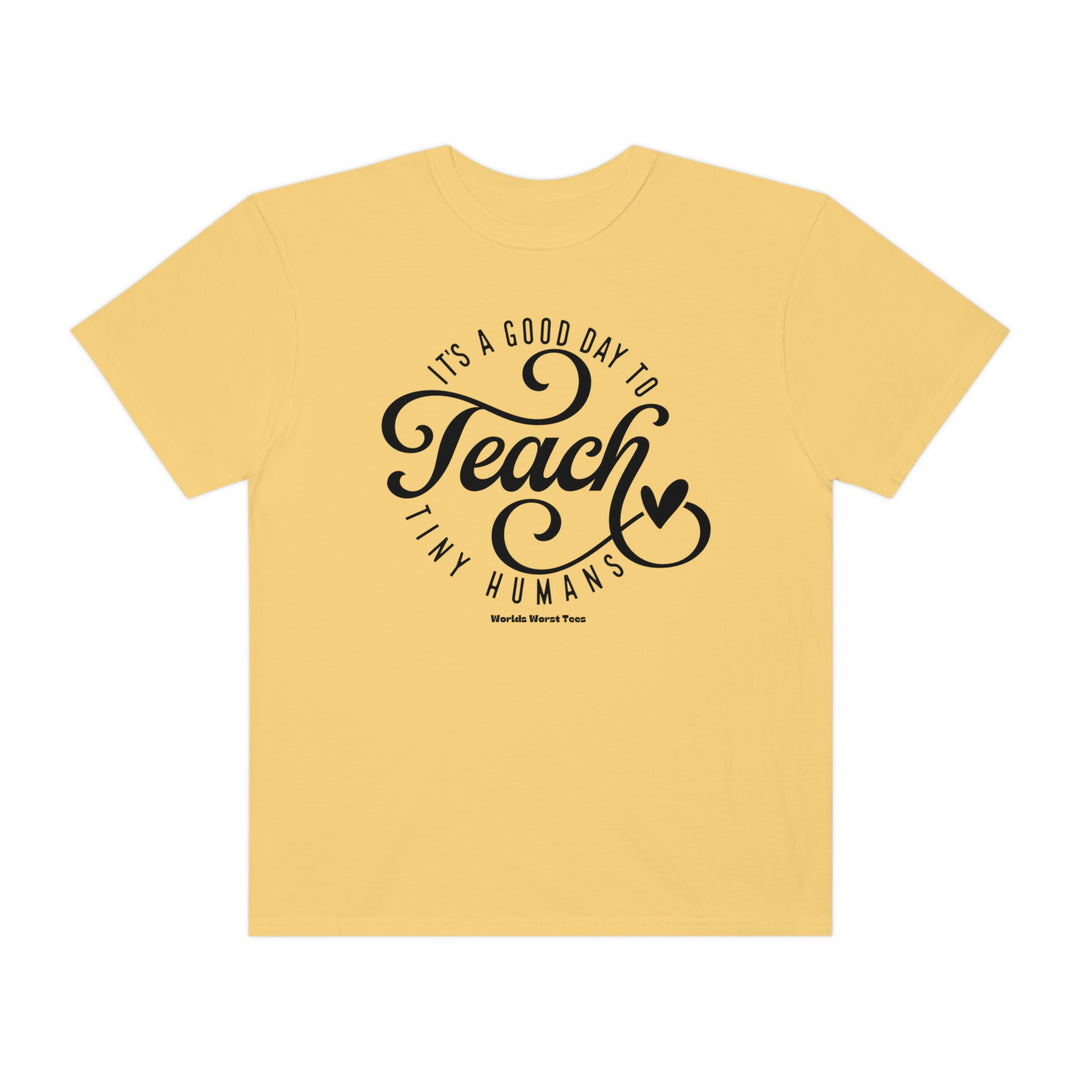 Unisex Teach Tiny Humans Tee, a yellow t-shirt with black text. Made of 80% ring-spun cotton and 20% polyester, featuring a relaxed fit and rolled-forward shoulder for comfort.