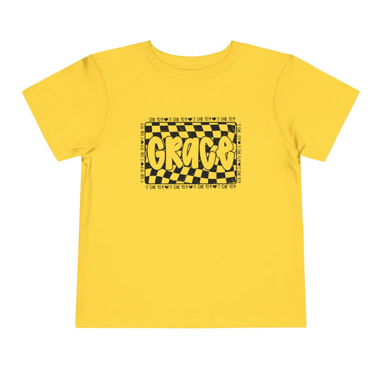 Grace Toddler Tee, a yellow short sleeve shirt featuring a black and yellow design, made from 100% Airlume combed cotton, offering comfort and style for kids.