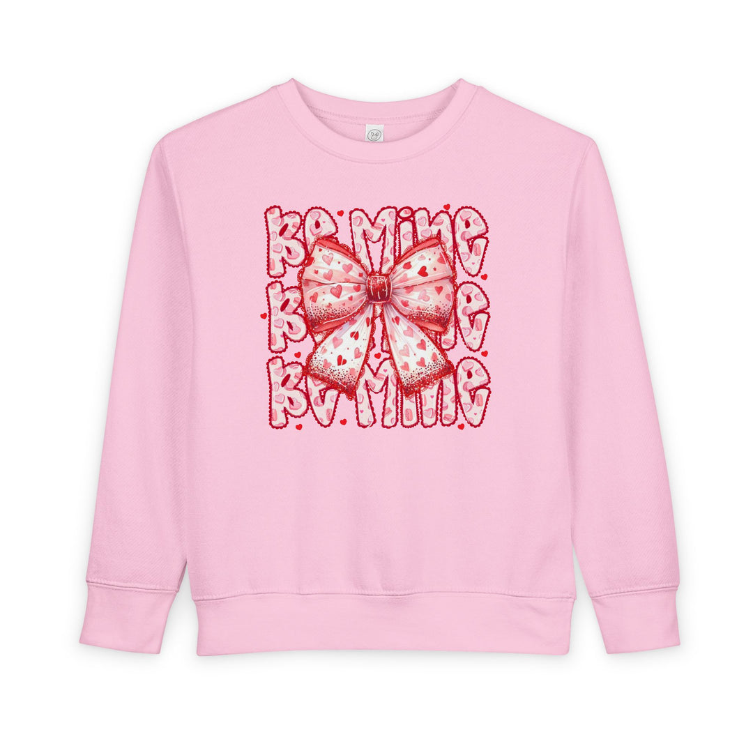 Be Mine Toddler Crew sweatshirt with heart-patterned bow graphic and BE MINE text, designed for warmth and durability in a soft cotton-polyester blend.