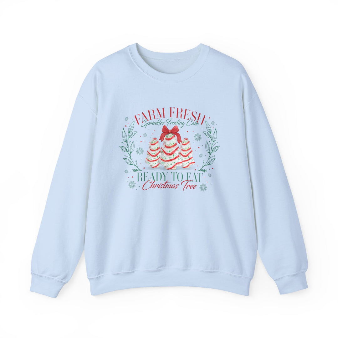 Light-blue crewneck sweatshirt displaying festive cake trees with Farm Fresh Sprinkles Frosting Cake text, blending comfort and holiday spirit from Faith Family Designs.