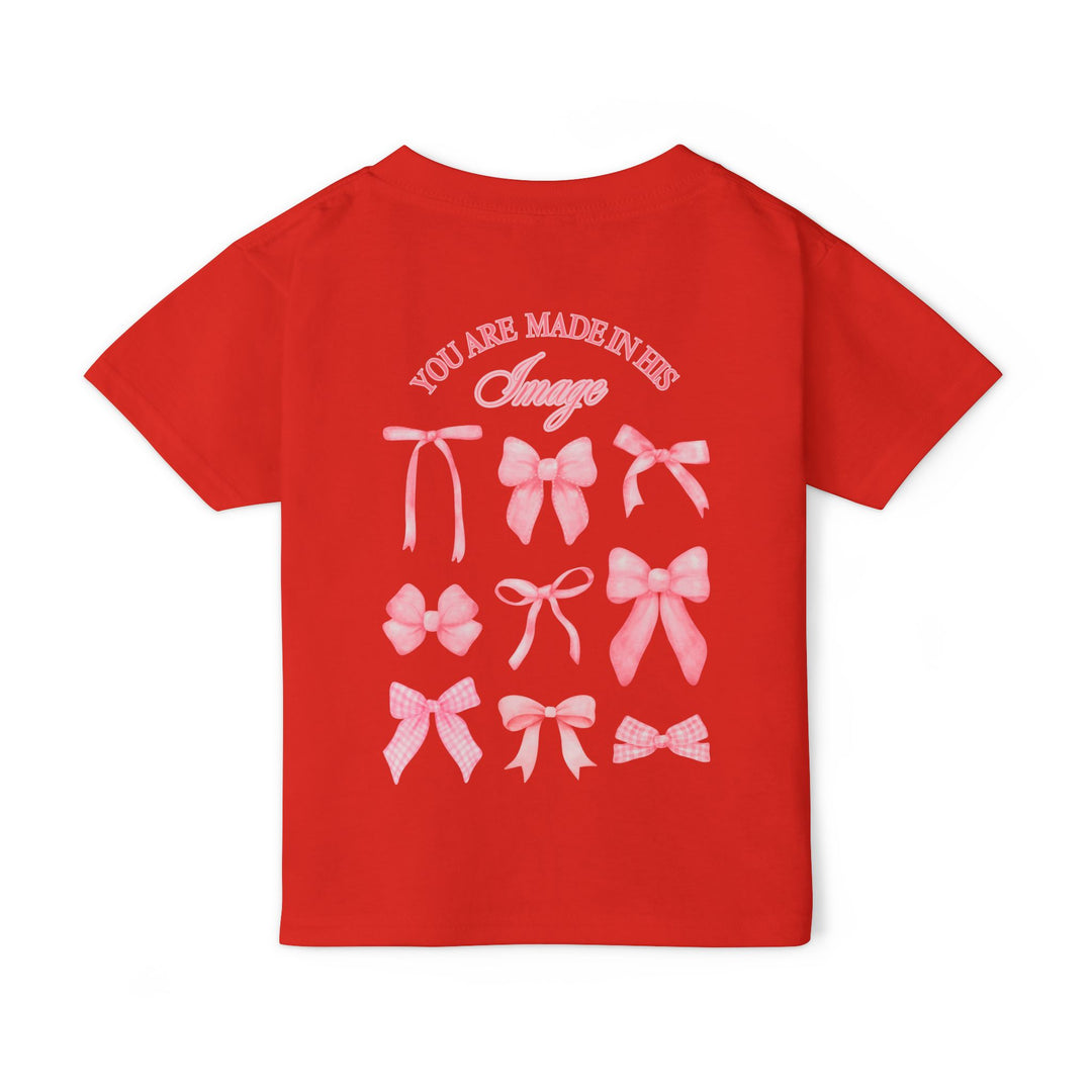 Back view of the Heavy Cotton™ Toddler T-shirt featuring a 3x3 grid of pink bows and the slogan “YOU ARE MADE IN HIS Image.”
