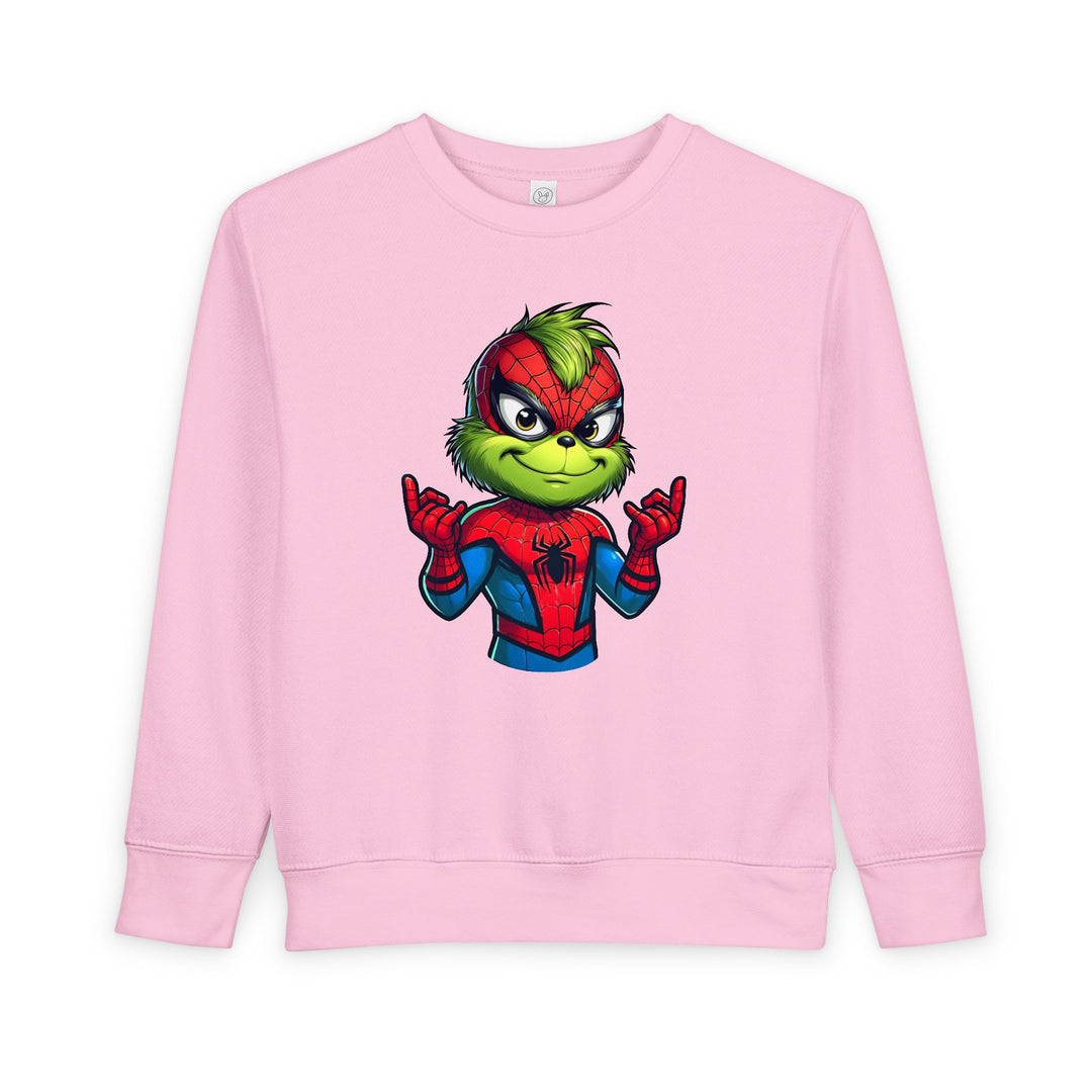 Light pink toddler sweatshirt with a Grinch-like character in a Spider-Man suit, web-shooting gesture, showcasing Faith Family Designs' playful style.
