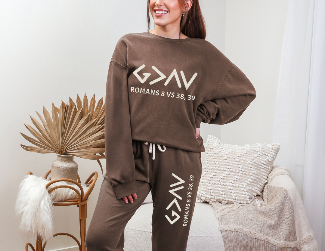 Woman wearing God is Greater Sweatpants, showcasing a relaxed fit with a vintage vibe, posing indoors. Ideal for adding retro style to your wardrobe.