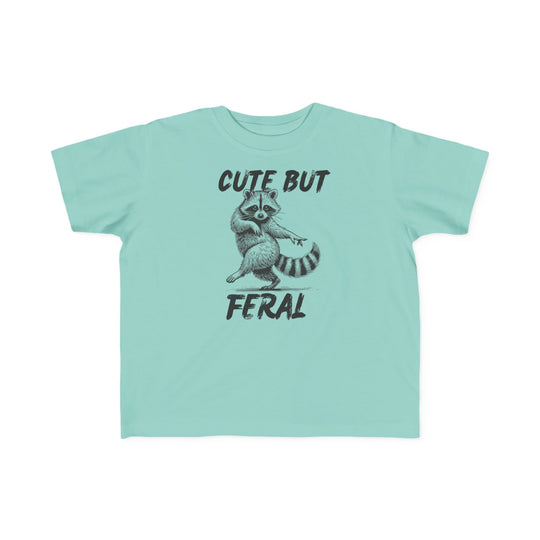 Cute but Feral Toddler Tee featuring a playful raccoon graphic and brushstroke text, perfect for toddlers with its soft, durable cotton fabric and classic fit.