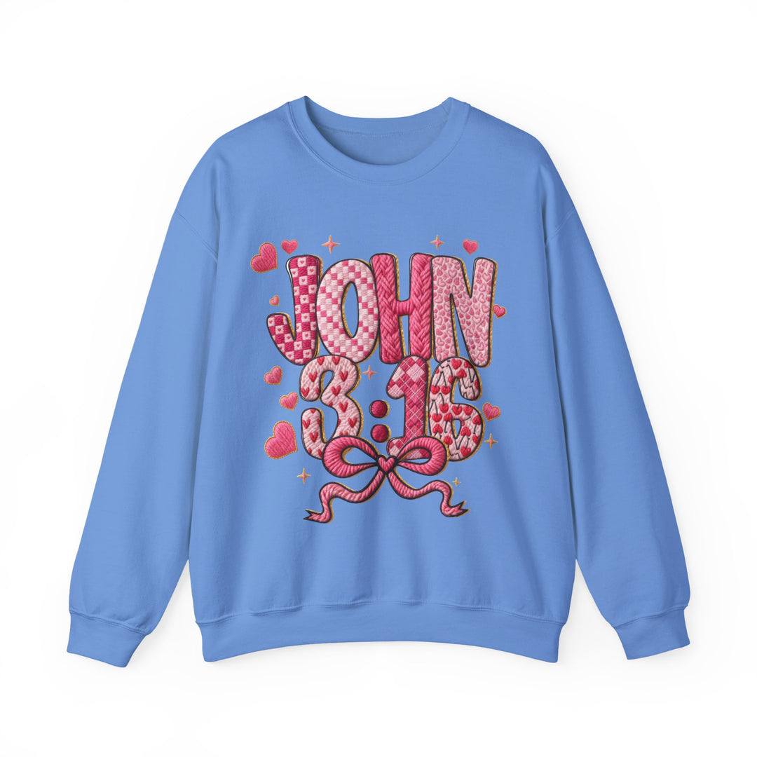 Light-blue crewneck sweatshirt with “JOHN 3:16” in pink patterns, adorned with hearts and sparkles. Comfortable polyester-cotton blend, ribbed collar, unisex fit.