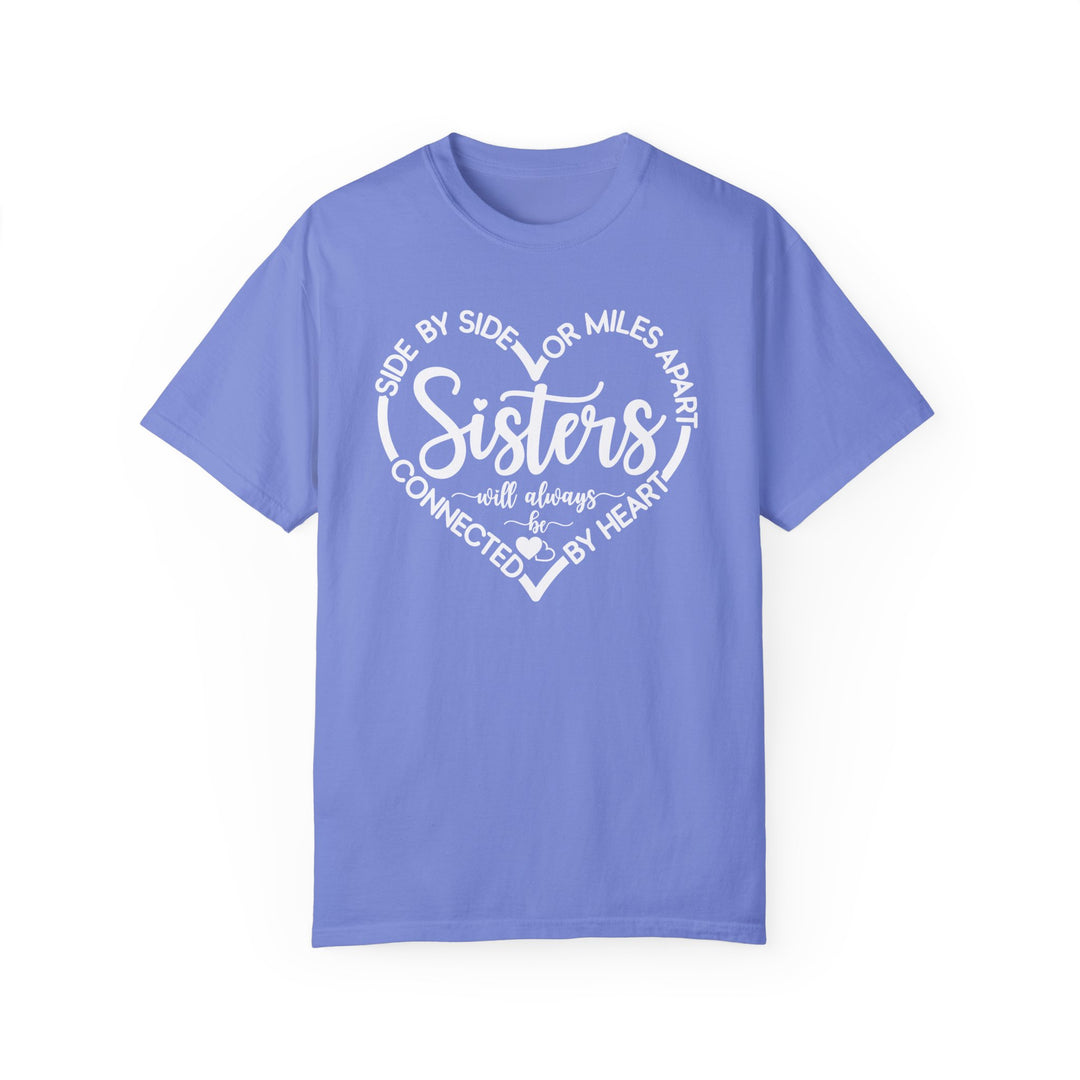 Sisters At Heart Tee: Blue t-shirt featuring white text, made with 100% ring-spun cotton, offering a relaxed fit and durable double-needle stitching.