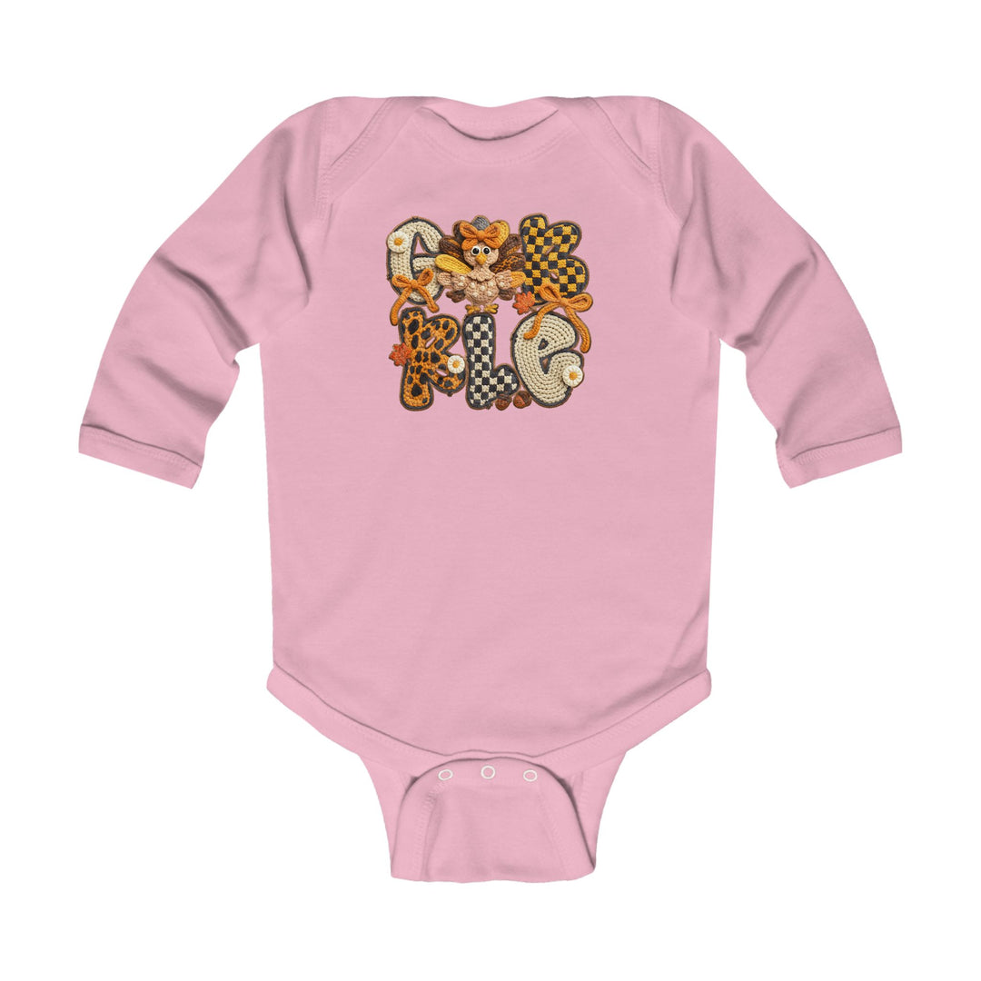 Gobble Onesie: Pink baby bodysuit featuring GOBBLE with fall-themed patterns and a whimsical turkey, designed for comfort with soft cotton and durable ribbed knitting.