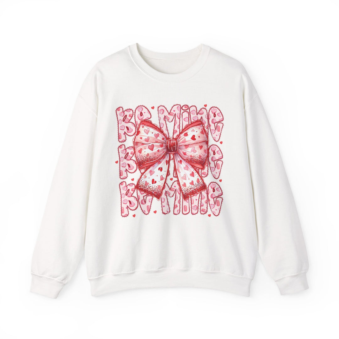 Be Mine Crew sweatshirt featuring a large pink-and-red bow with heart motifs, set against playful Valentine-themed lettering, embodying festive, stylish comfort.